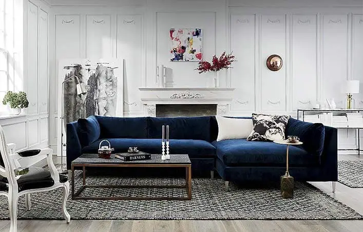 Salon blanc avec canapé bleu et tapis gris