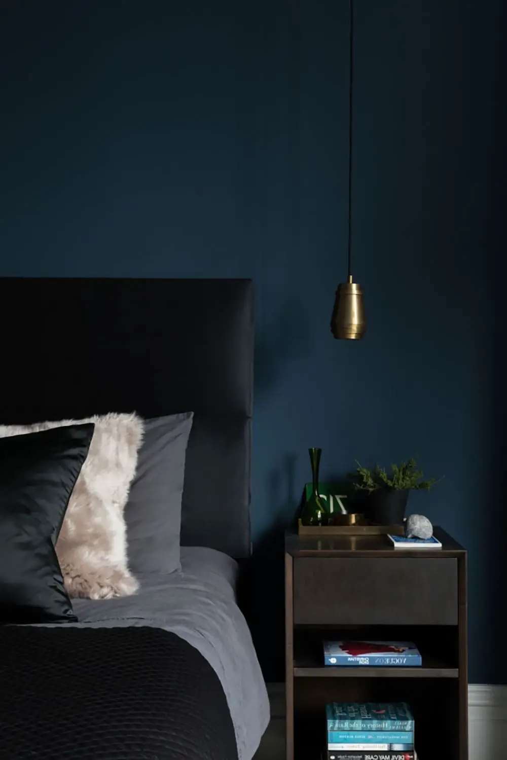 Chambre moderne et cosy avec tête de lit noire et murs bleu pétrole