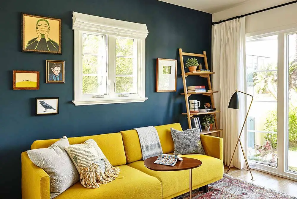 Salon cosy aux murs bleu avec un canapé jaune