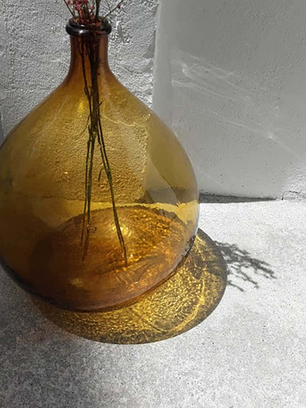 Bonbonne en verre de couleur marron translucide posée à même le sol - Decorazine.fr