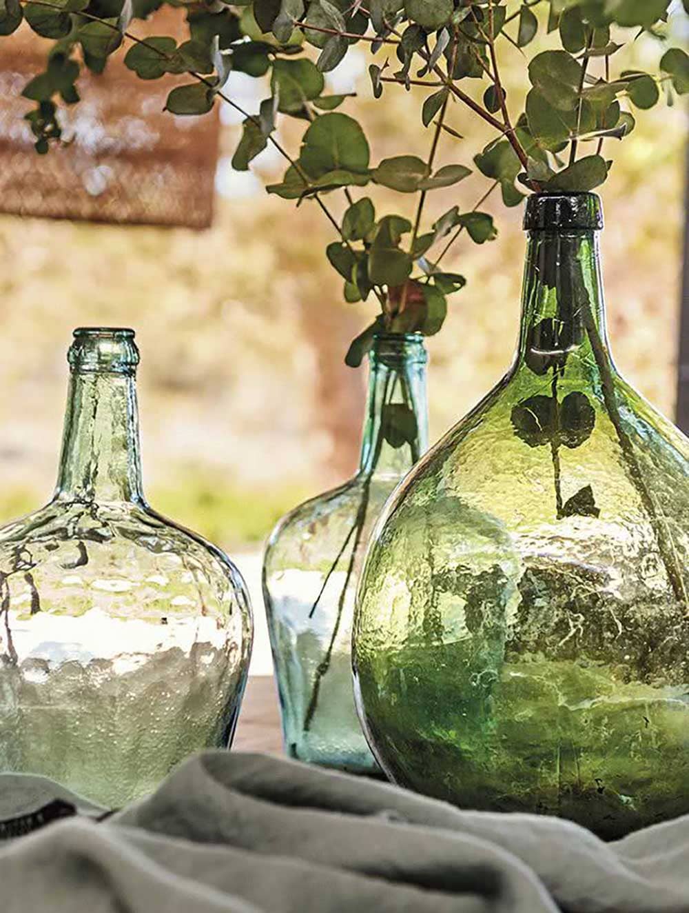 Bonbonnes en verre sur une table extérieure de Provence