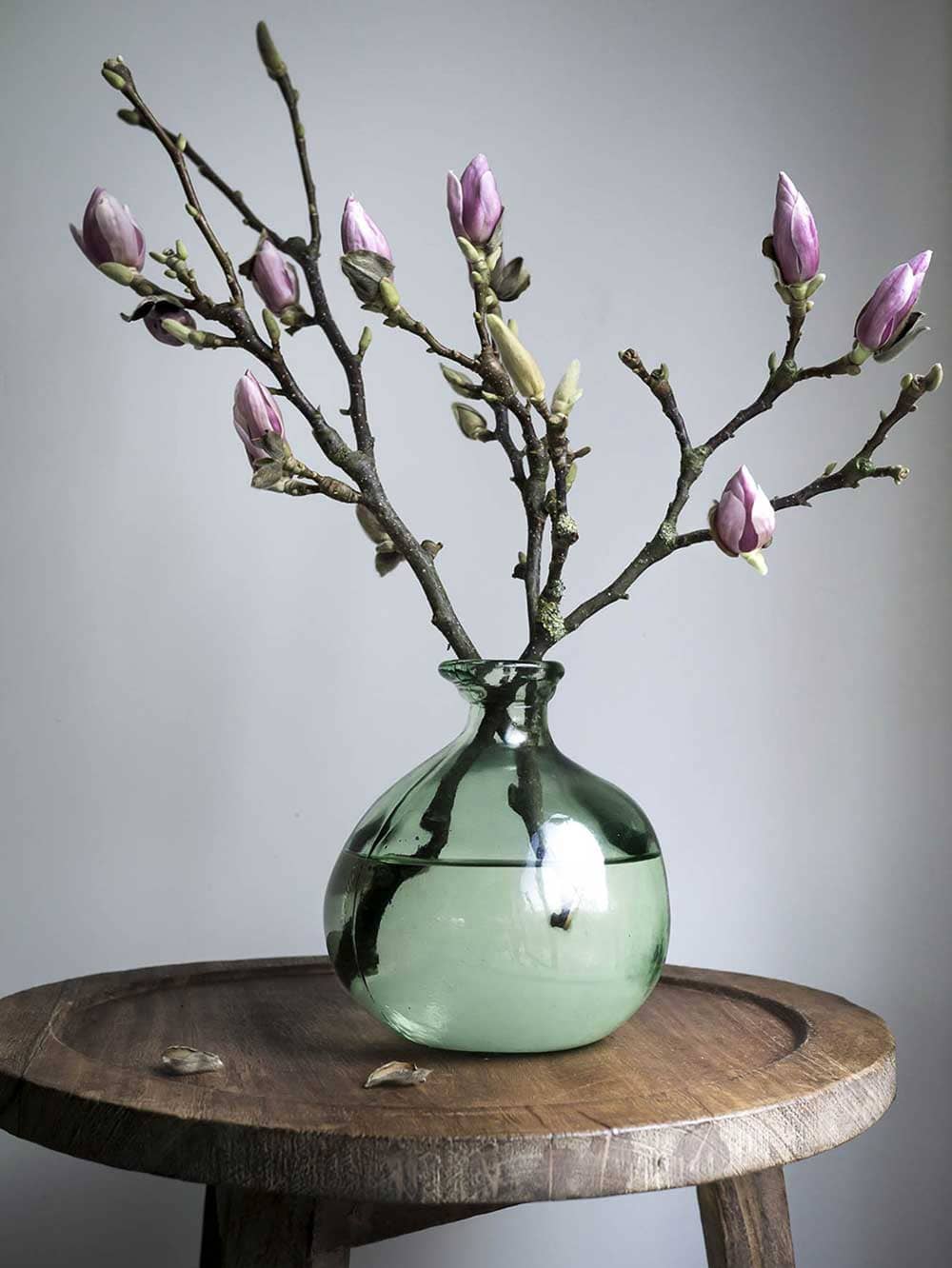 Vase rond en verre couleur verte clair avec branche fleurie - Decorazine.fr